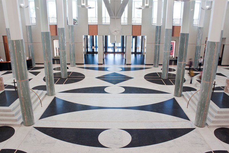 The Foyer at Parliament house, including the marble floors and columns, the front doors, and 2 staircases.