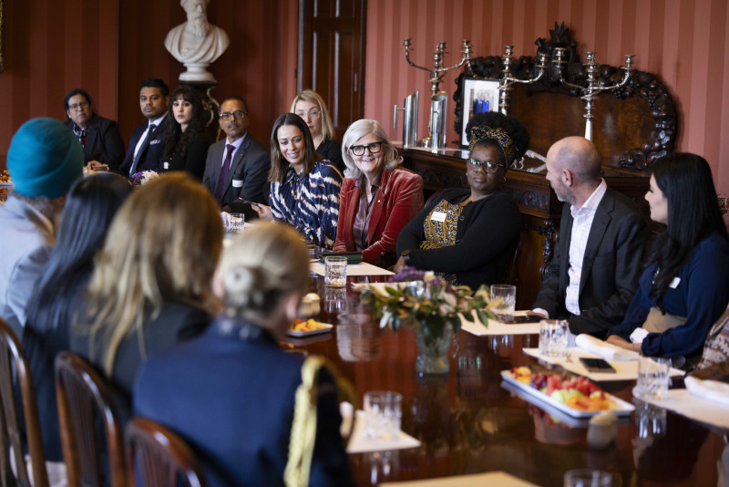 The Governor-General seated at a large table talking to community members.